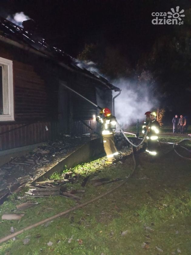 Pożar domu. Na schodach wejściowych kobieta